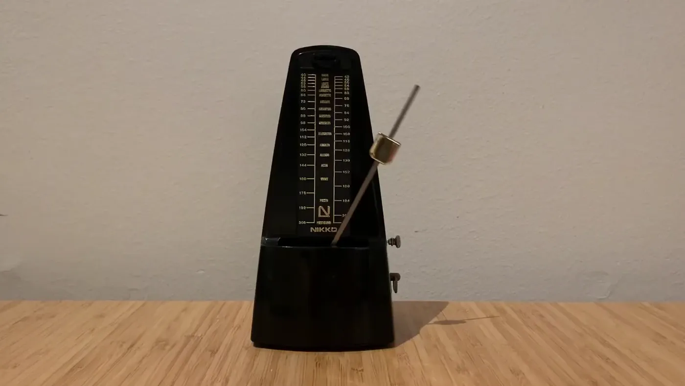 A metronome ticking on a wooden table